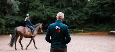 Male Coach Teaching A Rider And Horse