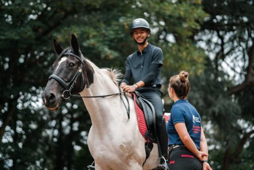 Rider on a piebald horse looking down to a coach