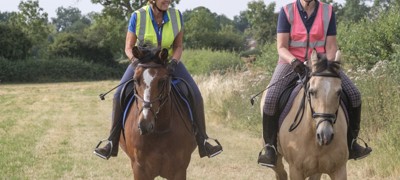 two smiling riders on horses
